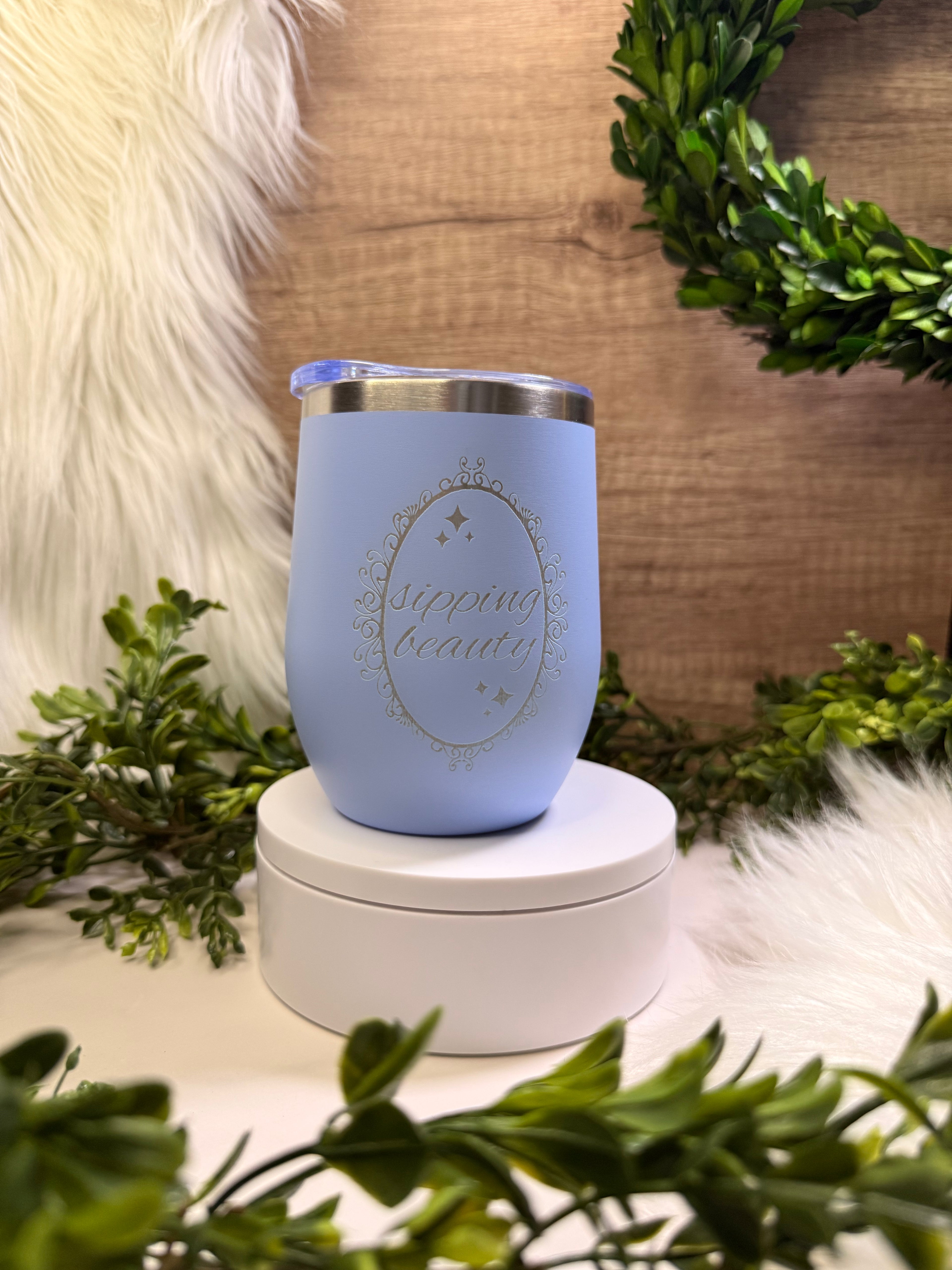 Light blue wine tumbler engraved with “Sipping Beauty” in elegant decorative frame
